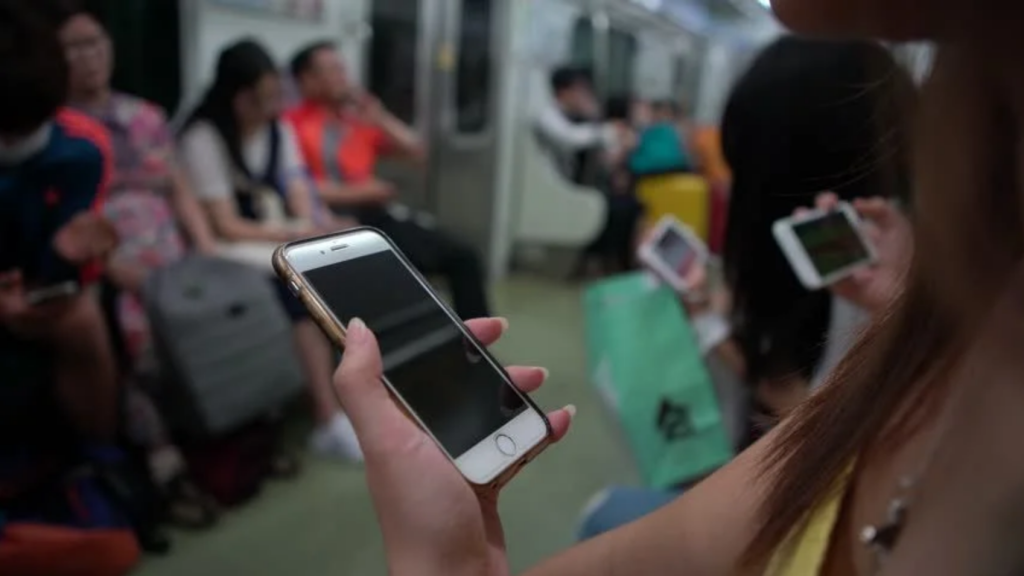 asian people using smartphone in subway train metro